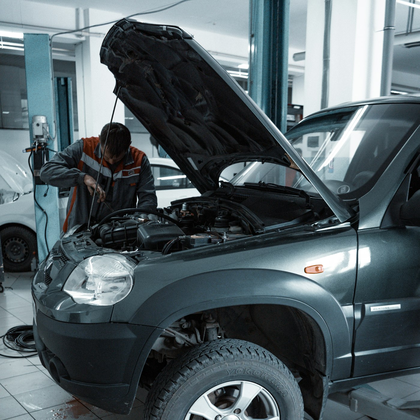 Technician inspecting a Toyota engine bay under the open hood